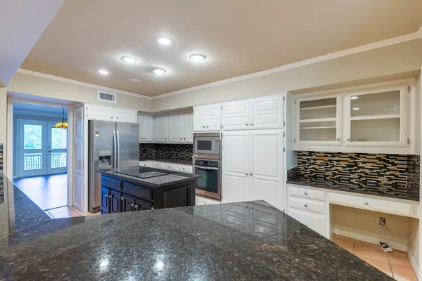 a kitchen with stainless steel appliances granite countertop a stove and a refrigerator