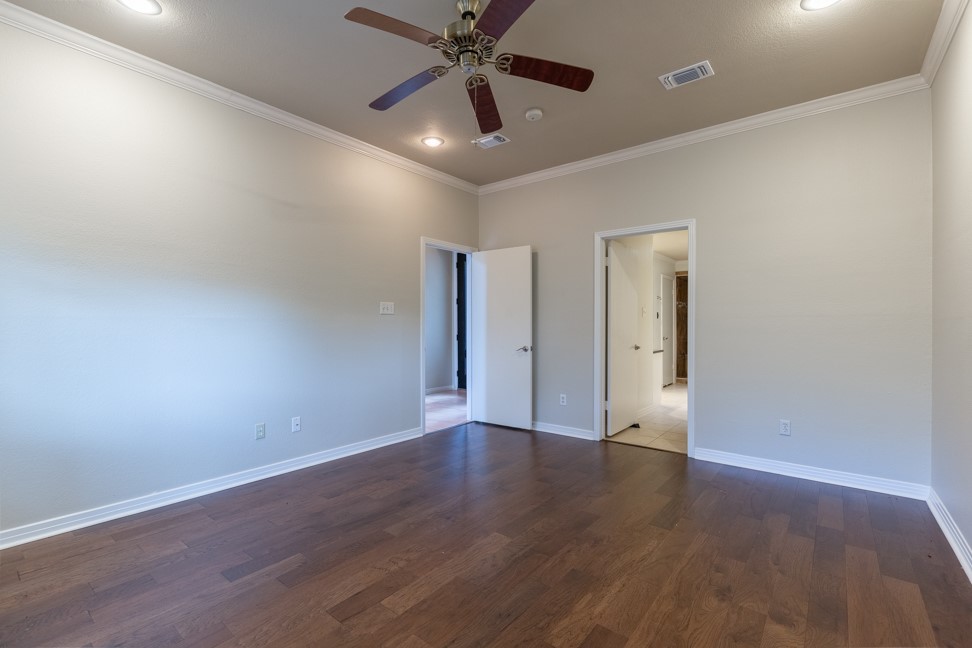 10907 Legends Lane Austin, TX 78747 - Photo 18 of 35 Unfurnished bedroom with crown molding, dark wood-style floors, recessed lighting, and ceiling fan