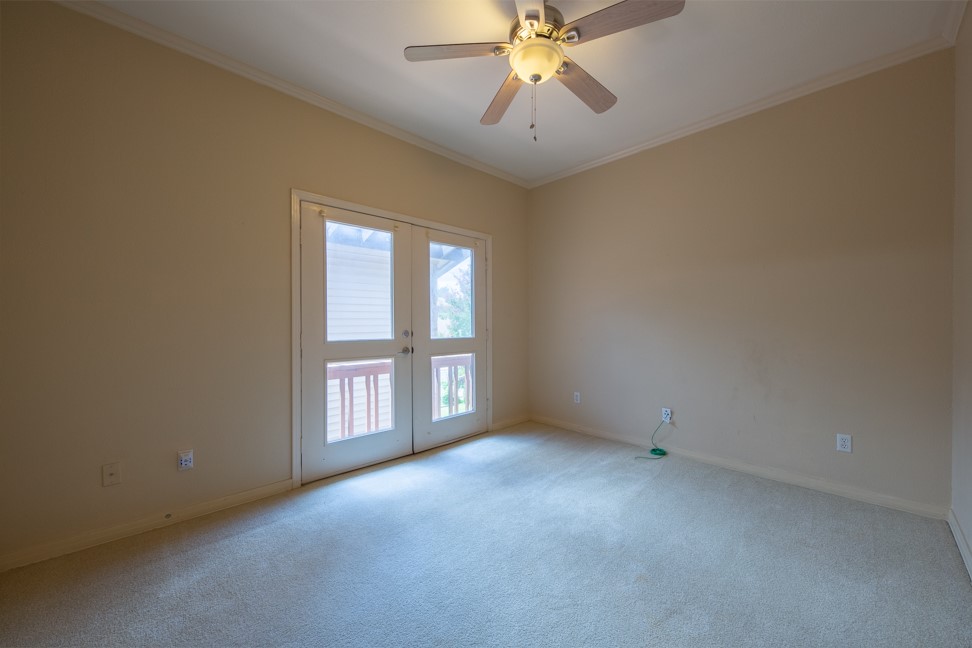 10907 Legends Lane Austin, TX 78747 - Photo 25 of 35 Unfurnished room with crown molding, light colored carpet, a ceiling fan, and french doors