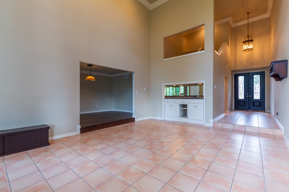 10907 Legends Lane Austin, TX 78747 - Photo 7 of 35 Foyer entrance featuring ornamental molding, a towering ceiling, light tile patterned floors, and french doors