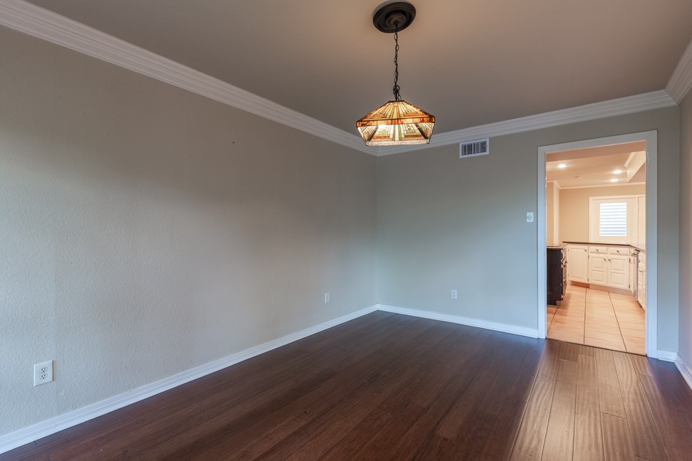 10907 Legends Lane Austin, TX 78747 - Photo 8 of 35 Spare room with ornamental molding and dark wood-style flooring