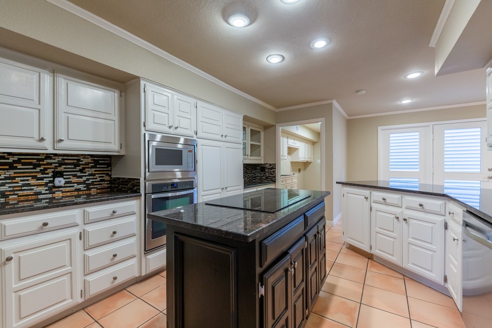 10907 Legends Lane Austin, TX 78747 - Photo 10 of 35 Kitchen with decorative backsplash, ornamental molding, white cabinets, stainless steel appliances, and recessed lighting