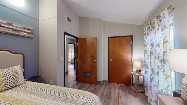 a bedroom with a bed and wooden floor