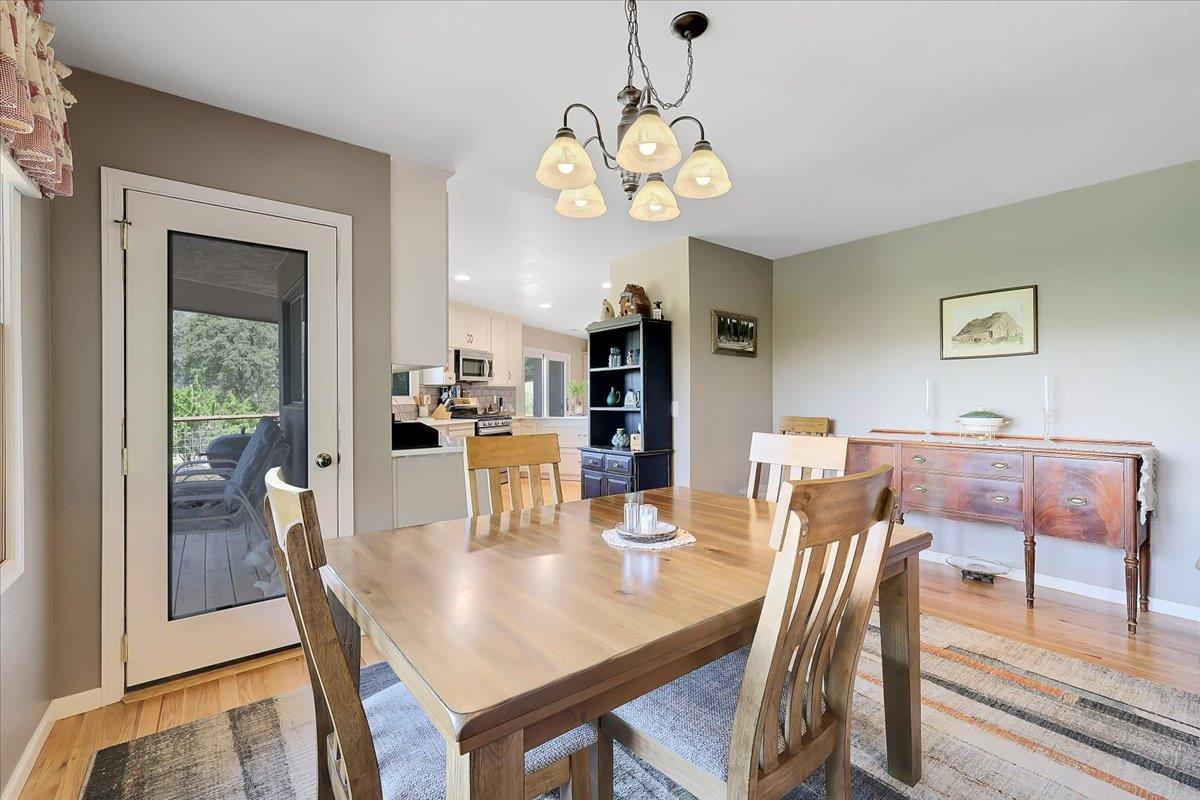 9521 Sicard Flat Road Browns Valley, CA 95918 - Photo 20 of 83 a dining room with wooden floor a chandelier a wooden table and chairs