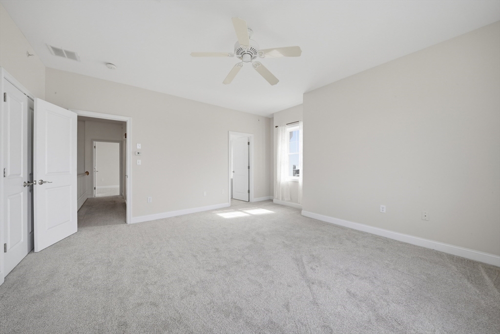 233 Beach Road, Unit A11 Salisbury, MA 01952 - Photo 24 of 37 a view of an empty room with a ceiling fan