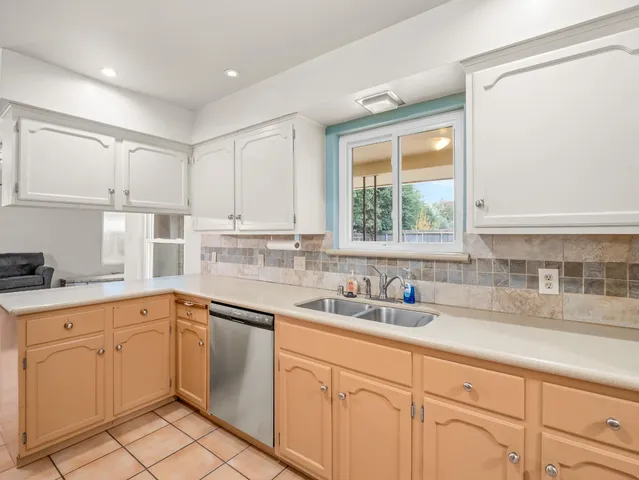 a kitchen with white cabinets white appliances and sink