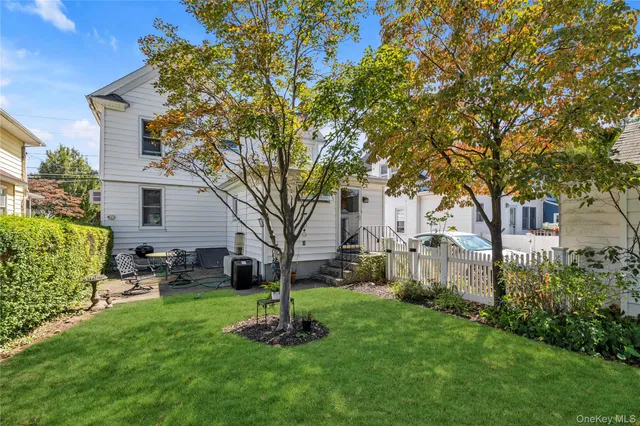 a front view of a house with a yard and tree