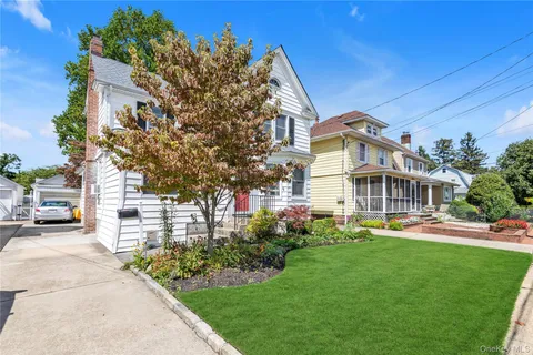 a front view of a house with a garden and plants