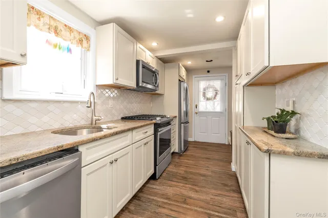 a kitchen with stainless steel appliances granite countertop a sink and a stove