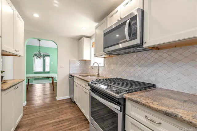 a kitchen with stainless steel appliances granite countertop a stove and a microwave
