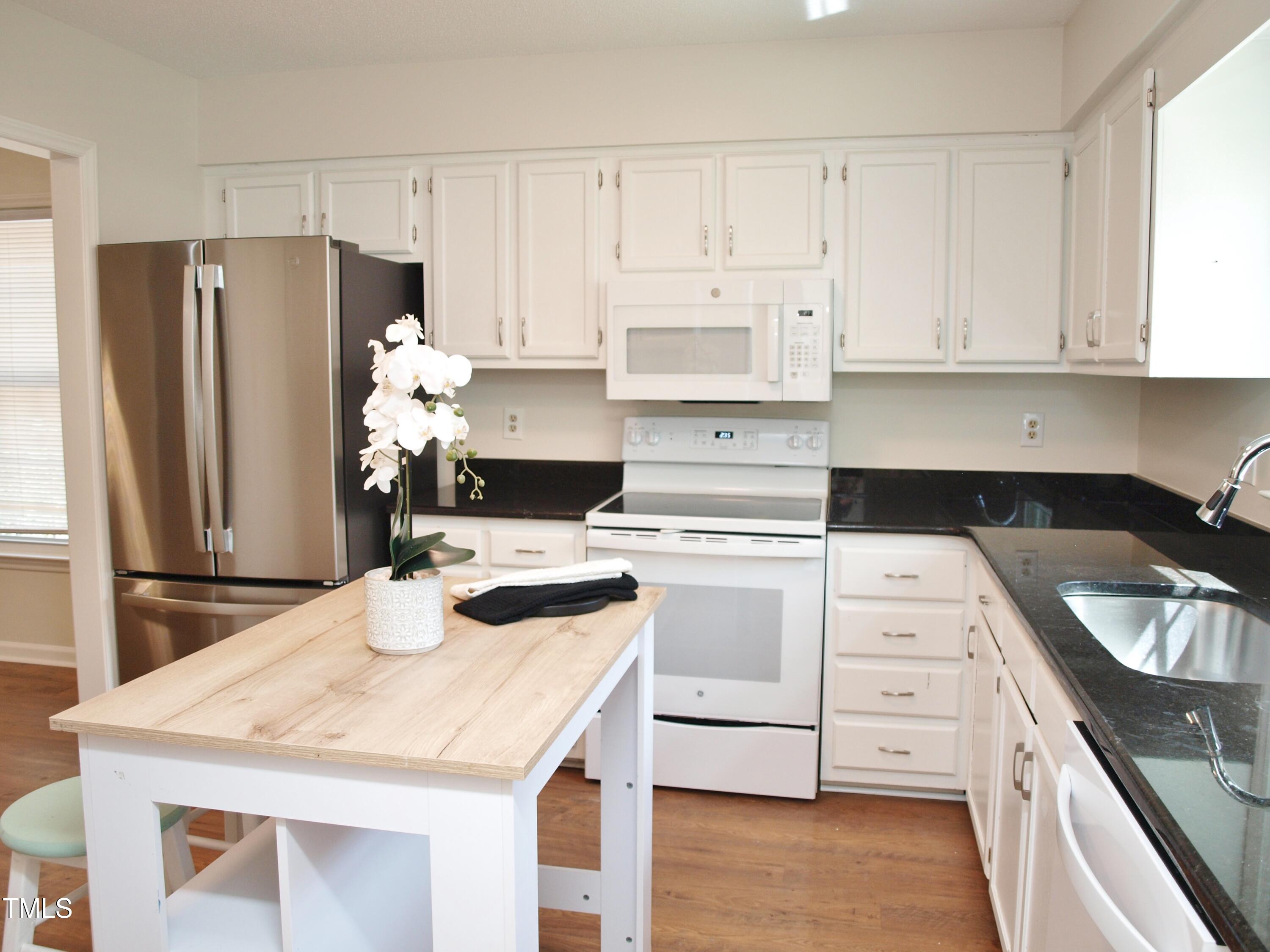 7429 Ashbury Court Raleigh, NC 27615 - Photo 4 of 16 a kitchen with a sink a stove and refrigerator