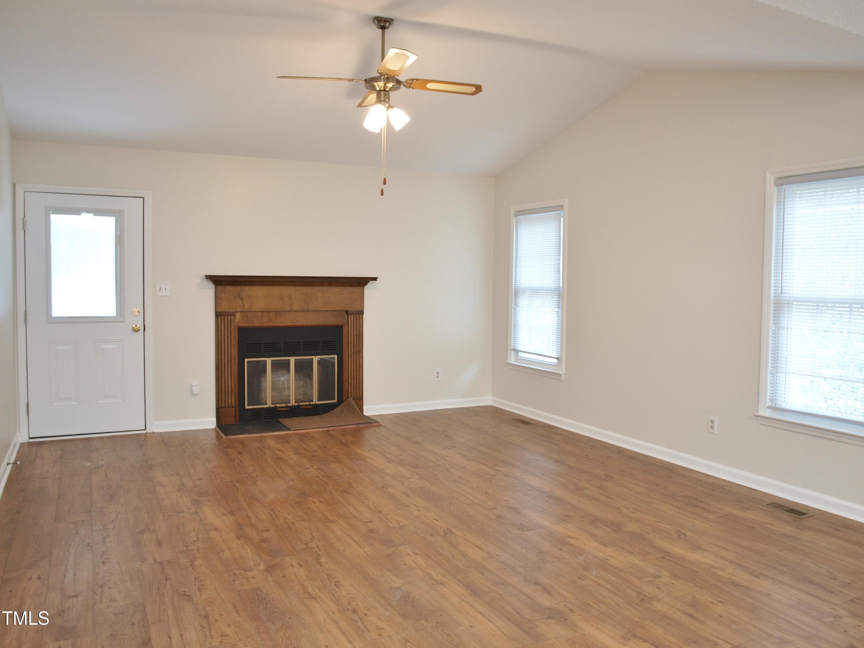 7429 Ashbury Court Raleigh, NC 27615 - Photo 7 of 16 an empty room with windows and fireplace