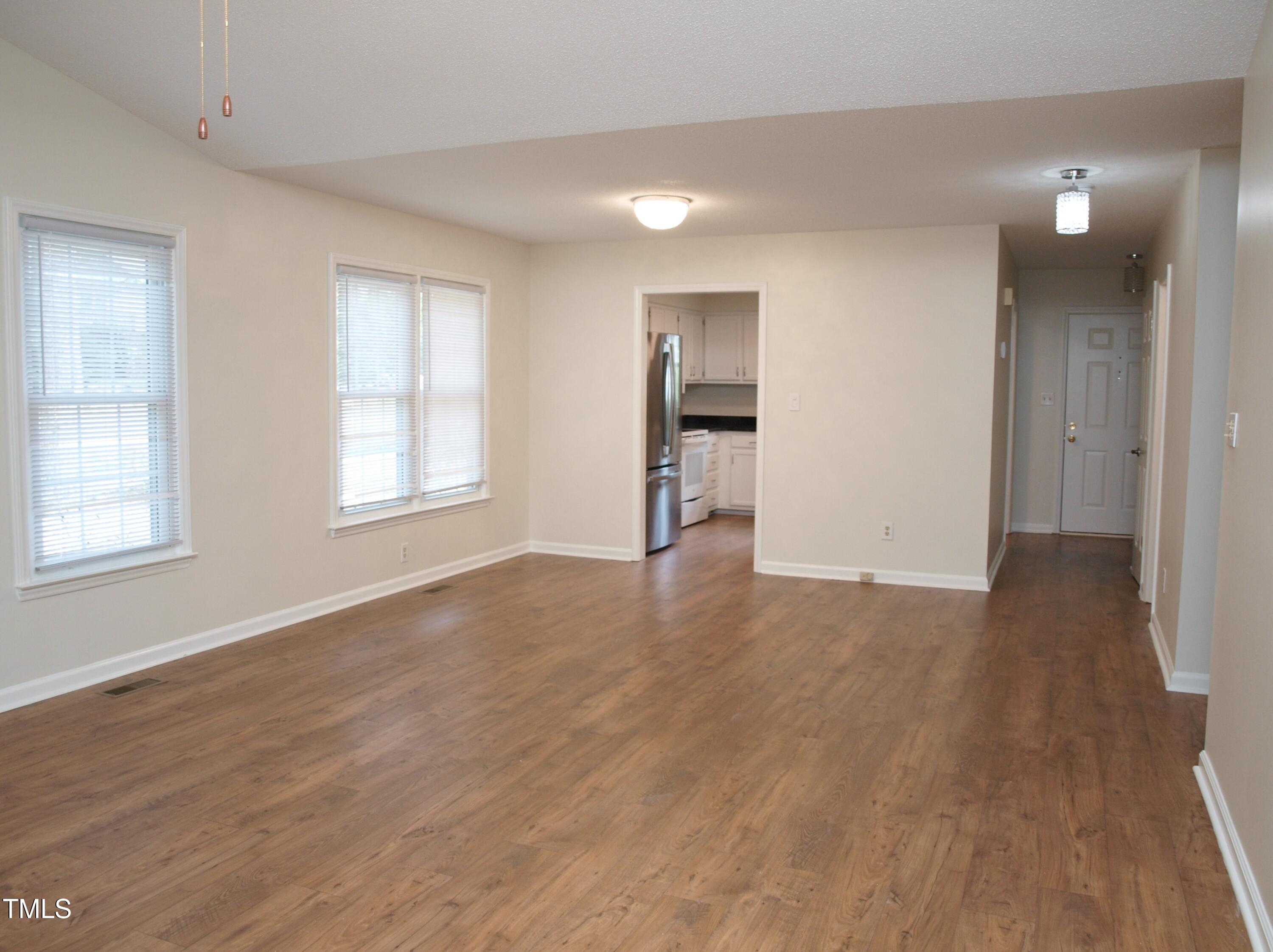 7429 Ashbury Court Raleigh, NC 27615 - Photo 8 of 16 an empty room with wooden floor and windows
