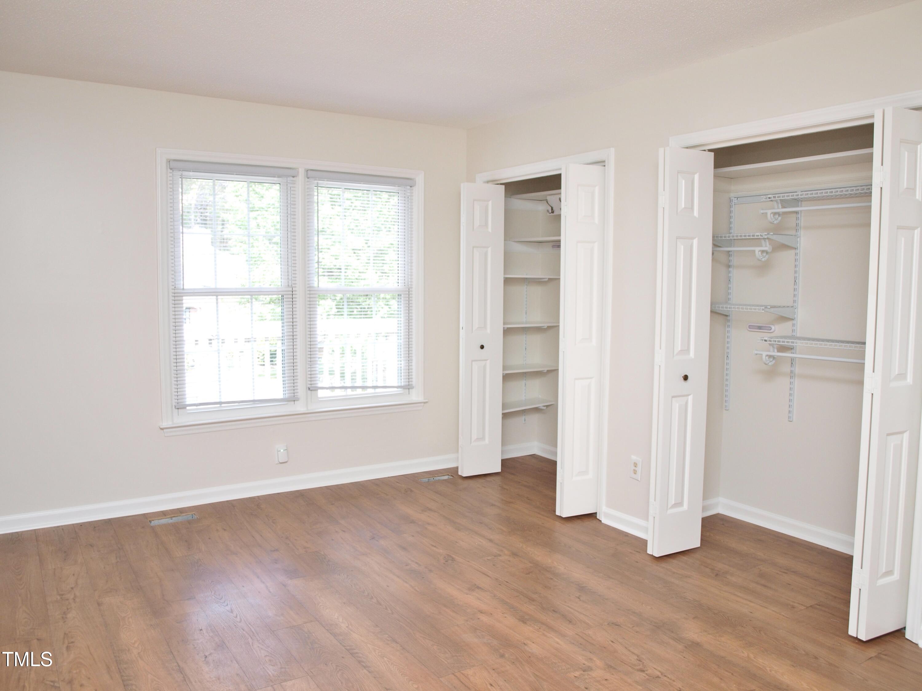 7429 Ashbury Court Raleigh, NC 27615 - Photo 9 of 16 an empty room with wooden floor closet and windows