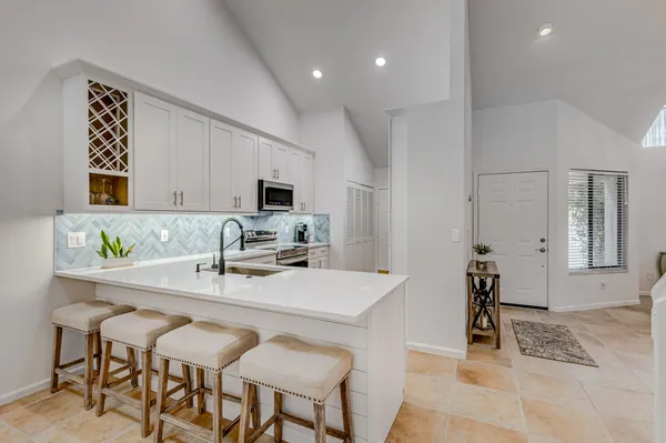 a kitchen with a dining table cabinets and appliances
