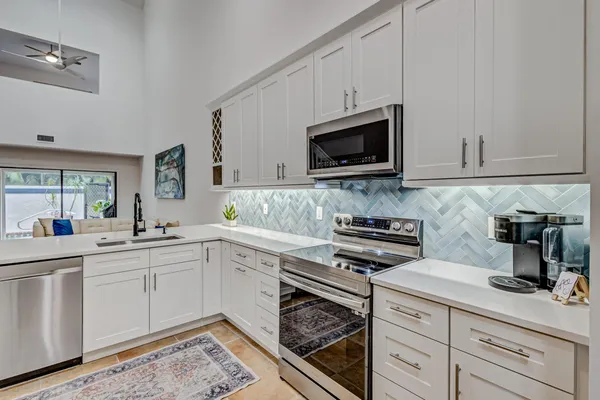 a kitchen with kitchen island a counter top space a sink and stainless steel appliances