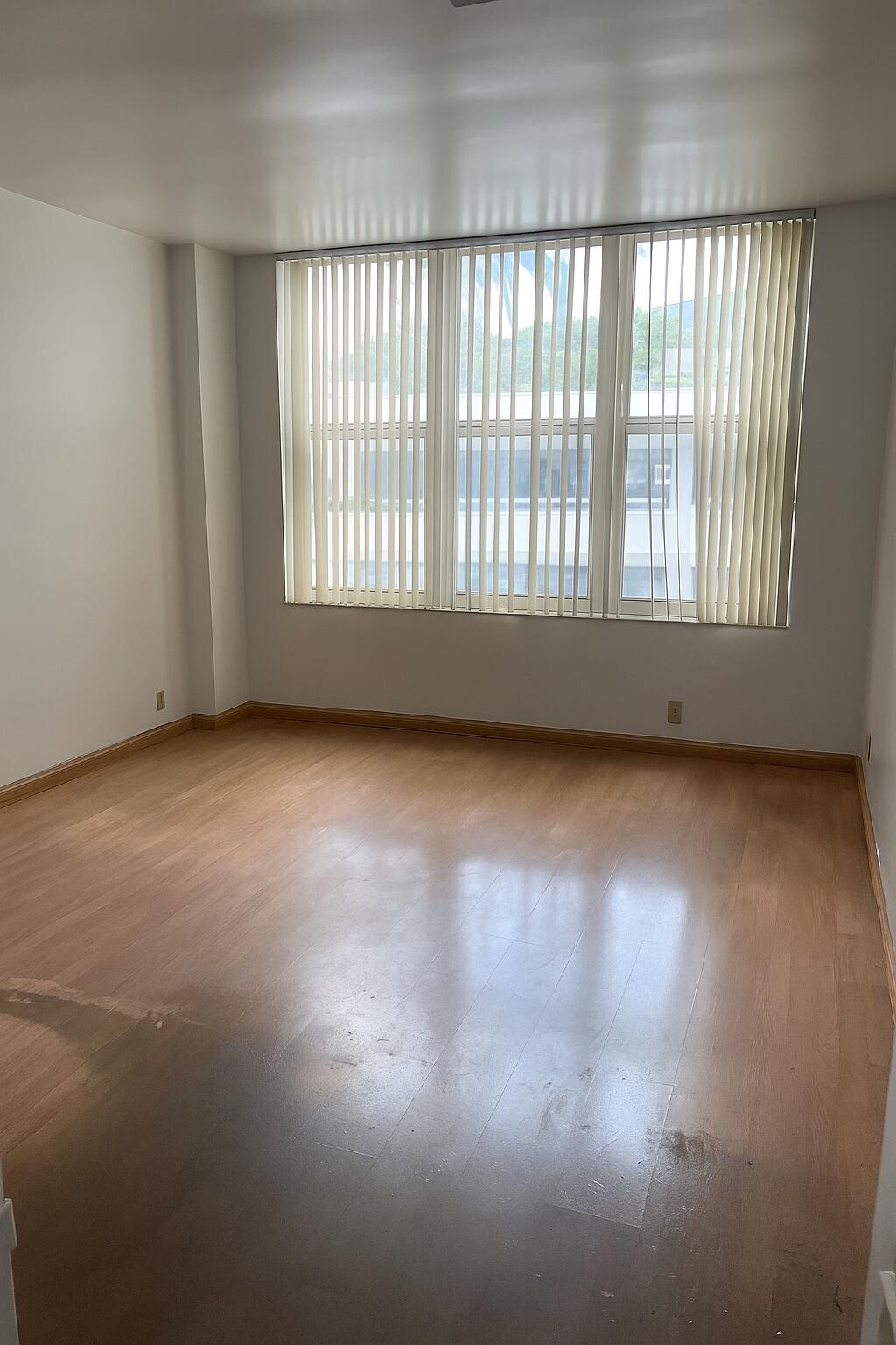 4747 Collins Avenue, Unit 305 Miami Beach, FL 33140 - Photo 8 of 12 an empty room with wooden floor and windows