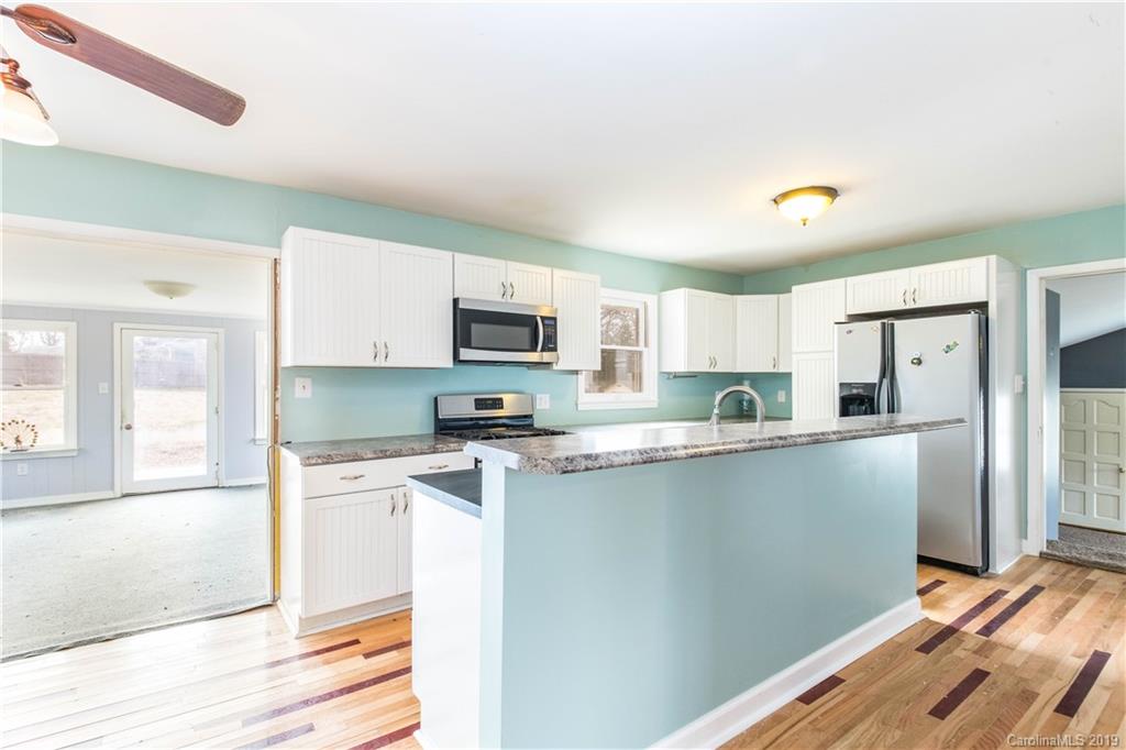 13800 Huntersville-Concord Road Huntersville, NC 28078 - Photo 5 of 16 a kitchen with stainless steel appliances white cabinets and wooden floor
