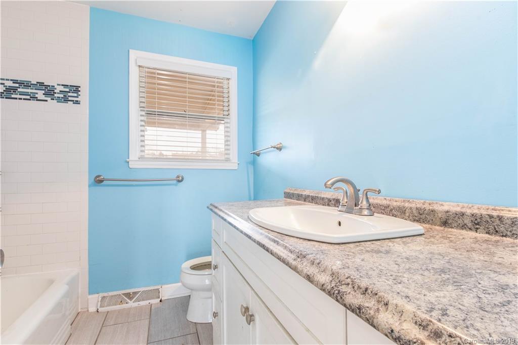 13800 Huntersville-Concord Road Huntersville, NC 28078 - Photo 8 of 16 a bathroom with a granite countertop sink a toilet and a window