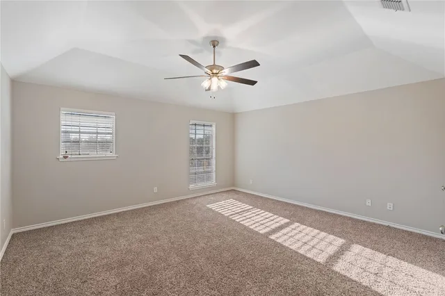 a view of a room with windows and ceiling fan
