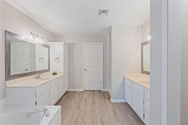 a bathroom with a tub sink and mirror
