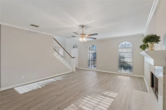 a view of a livingroom with wooden floor and a ceiling fan