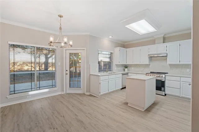 a kitchen with a refrigerator and white cabinets