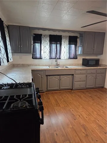 a large kitchen with granite countertop a stove and a sink