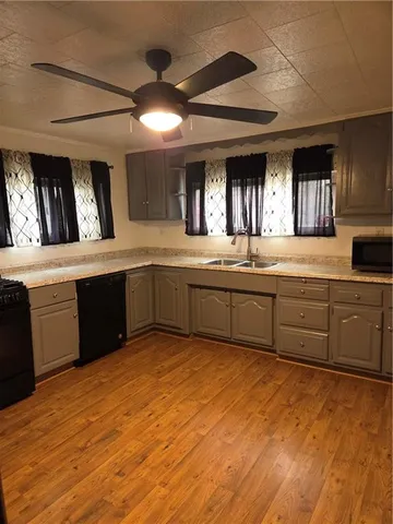 a kitchen with stainless steel appliances granite countertop a sink counter space cabinets and a large window