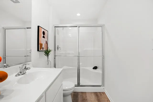 a bathroom with a sink a toilet and shower