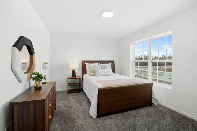 a bed sitting in a bedroom next to a window