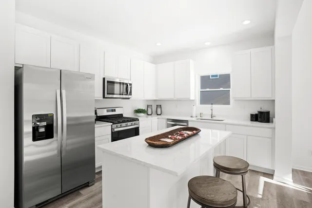 a kitchen with a refrigerator stove and white cabinets