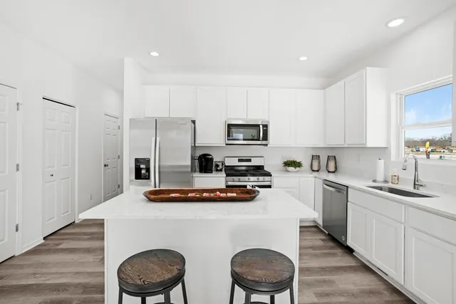 a kitchen with sink a stove and chairs