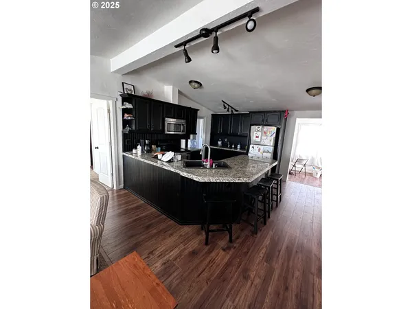 a living room with stainless steel appliances kitchen island granite countertop furniture and a view of kitchen