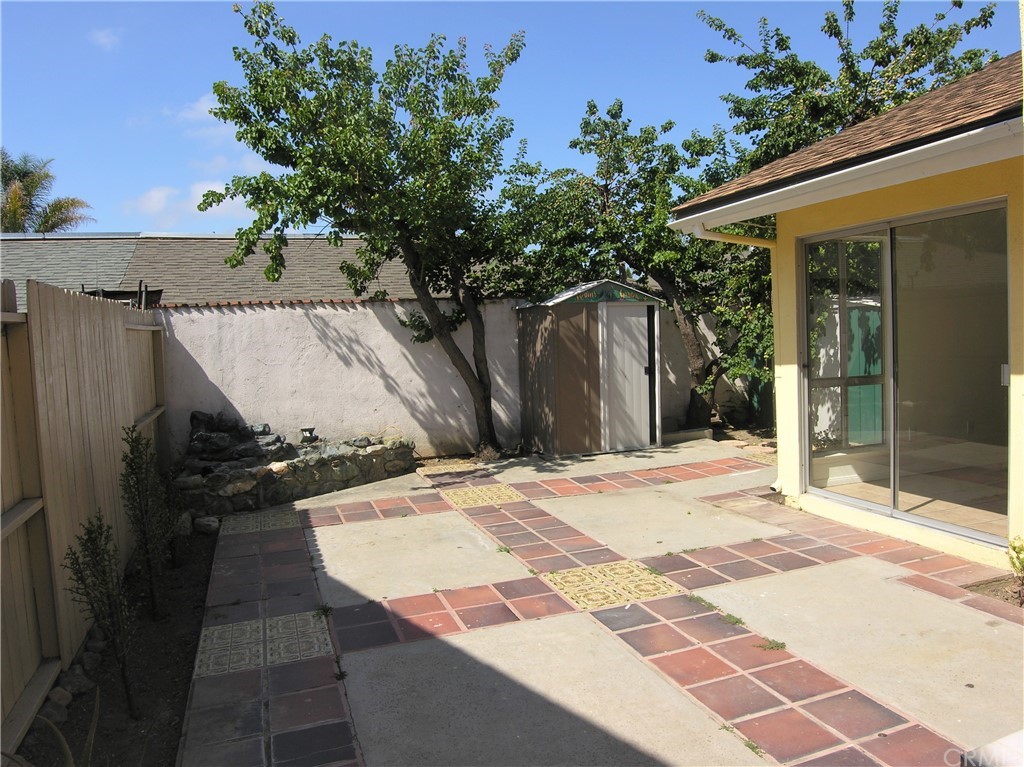 a patio with table and chairs and potted plants
