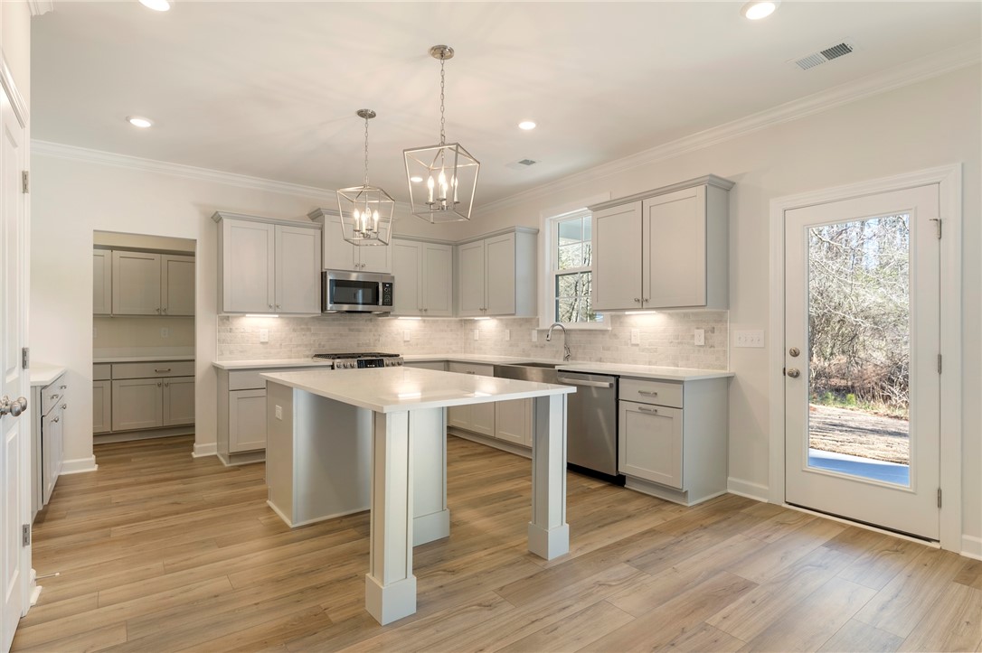 707 Weathered Oak Way Anderson, SC 29621 - Photo 10 of 28 This kitchen features sleek countertops, modern appliances, and convenient outdoor access.
