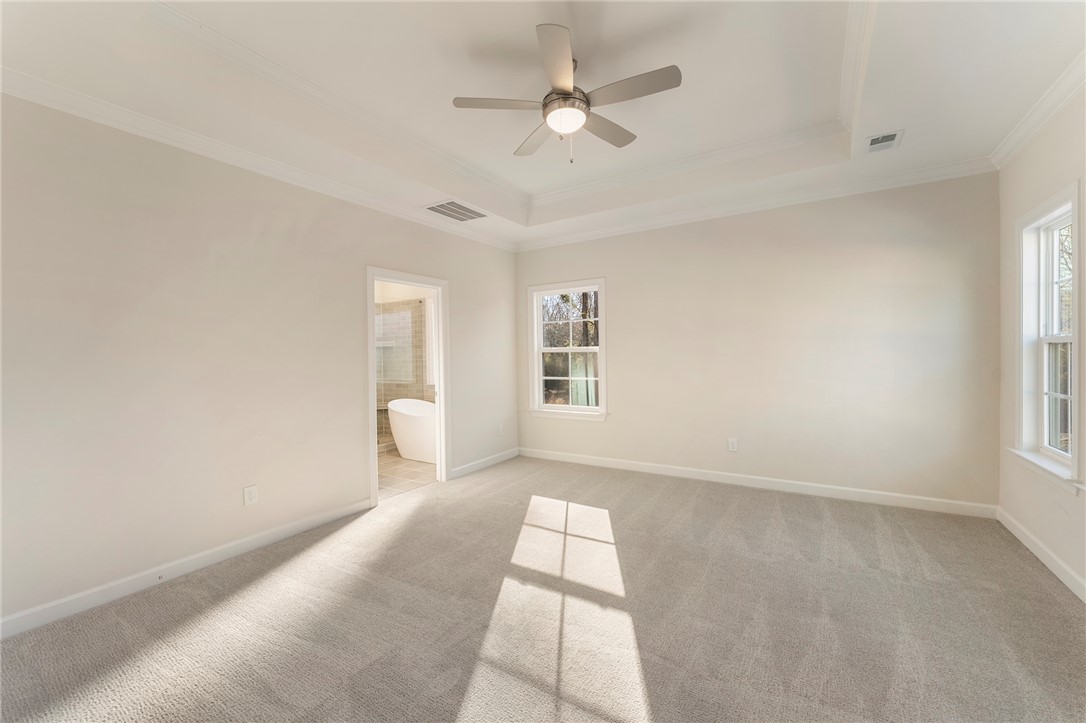 707 Weathered Oak Way Anderson, SC 29621 - Photo 13 of 28 This airy bedroom offers a serene retreat, featuring a tray ceiling and plush carpeting.
