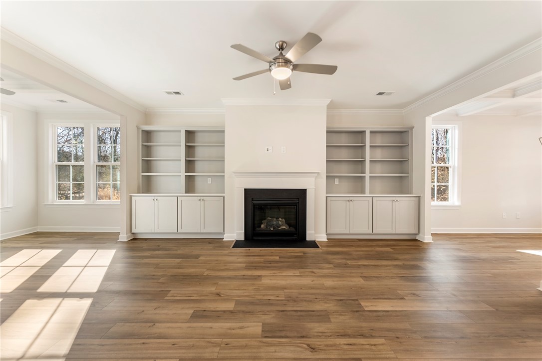 707 Weathered Oak Way Anderson, SC 29621 - Photo 5 of 28 This living area features a fireplace with built-in shelving, durable flooring, and bright windows.