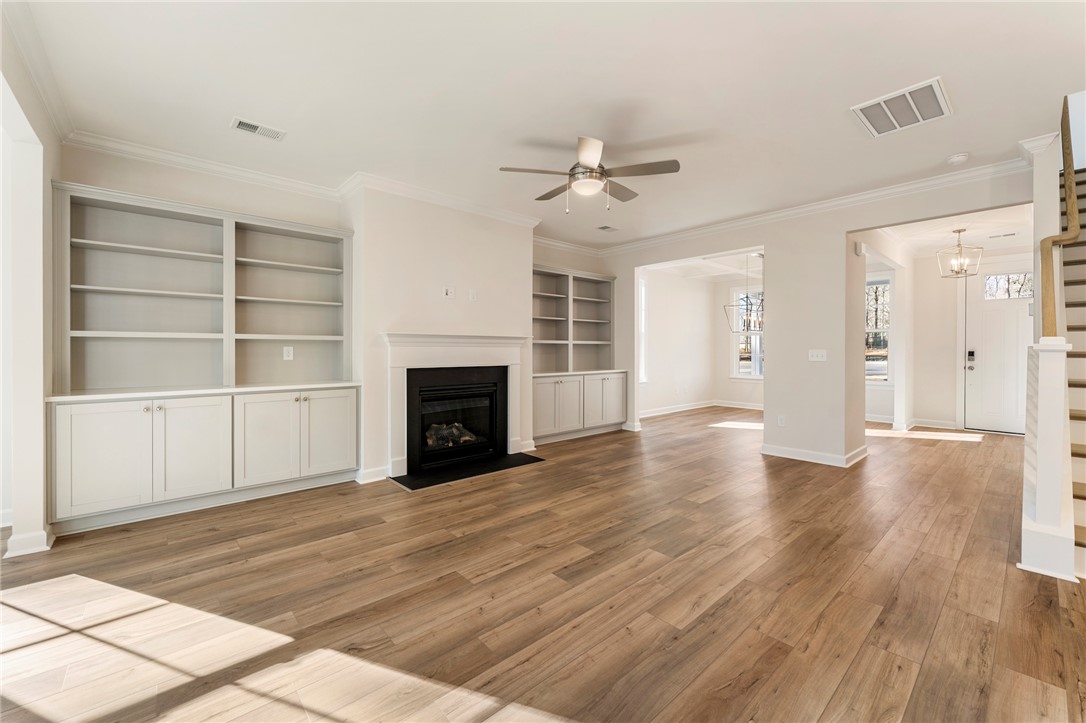 707 Weathered Oak Way Anderson, SC 29621 - Photo 6 of 28 This inviting space features a cozy fireplace, built-in shelving, and warm wood flooring.