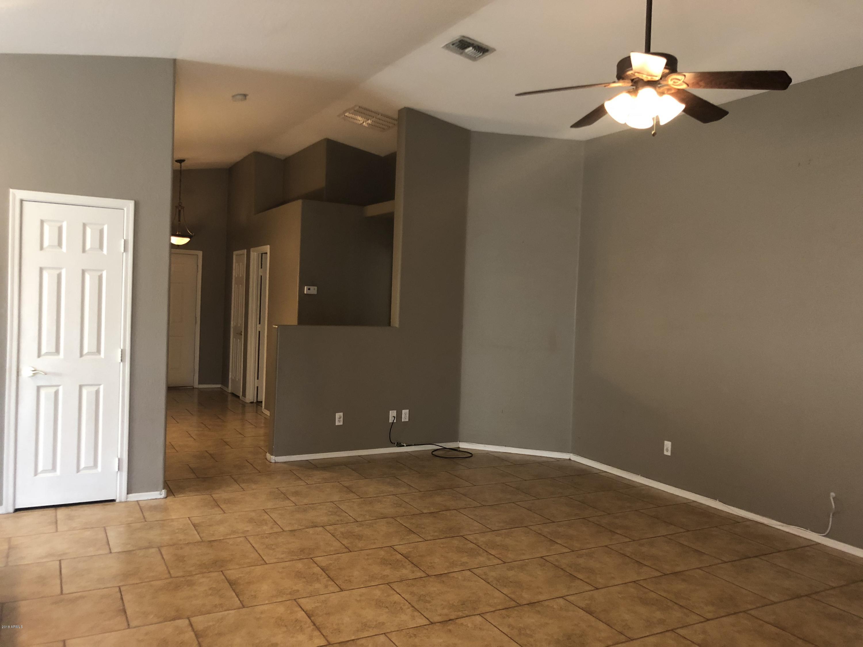 2321 West Maldonado Road Phoenix, AZ 85041 - Photo 8 of 44 a view of a chandelier fan and hardwood floor