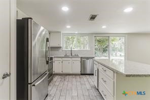 12011 Scribe Drive Austin, TX 78759 - Photo 4 of 14 a kitchen with granite countertop cabinets appliances and a sink