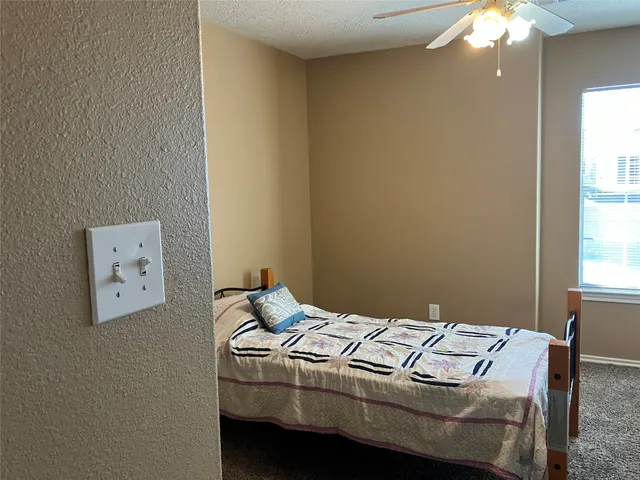 a bed sitting in a bedroom next to a window