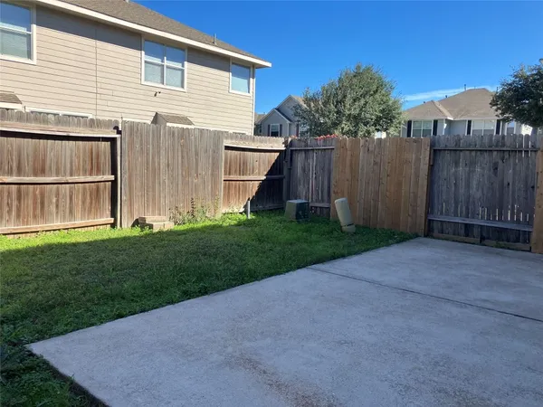 a view of backyard with small cabin and wooden fence
