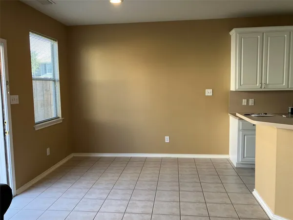 a view of a kitchen with white cabinets and a window