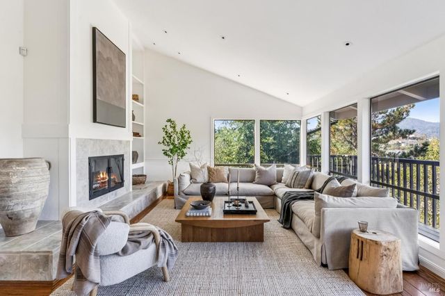 a living room with furniture fireplace and a large window