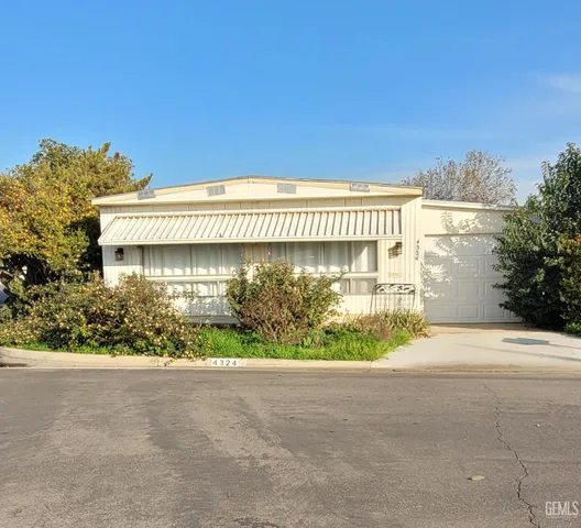 a front view of a house with a garden and plants