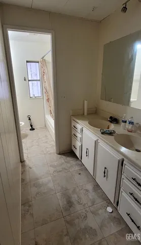 a bathroom with a double vanity sink a mirror and a bathtub