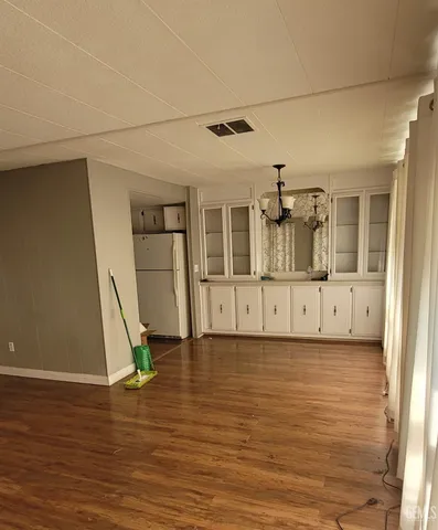 a view of a hallway with wooden floor and entryway