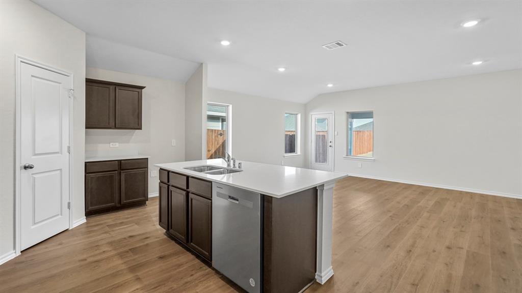 1953 Freeman Street Tyler, TX 75704 - Photo 2 of 32 Open-concept living space featuring wood-finish flooring, recessed lighting, and a kitchen island with an integrated sink and dishwasher