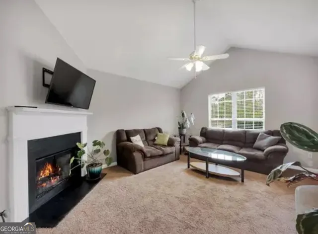 a living room with furniture a fireplace and a flat screen tv